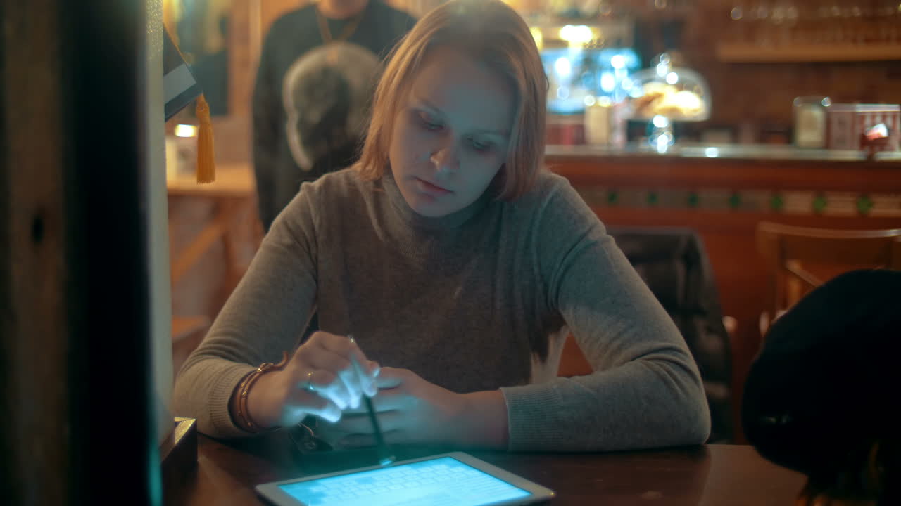 Donna che usa un tablet PC con stilo al bar