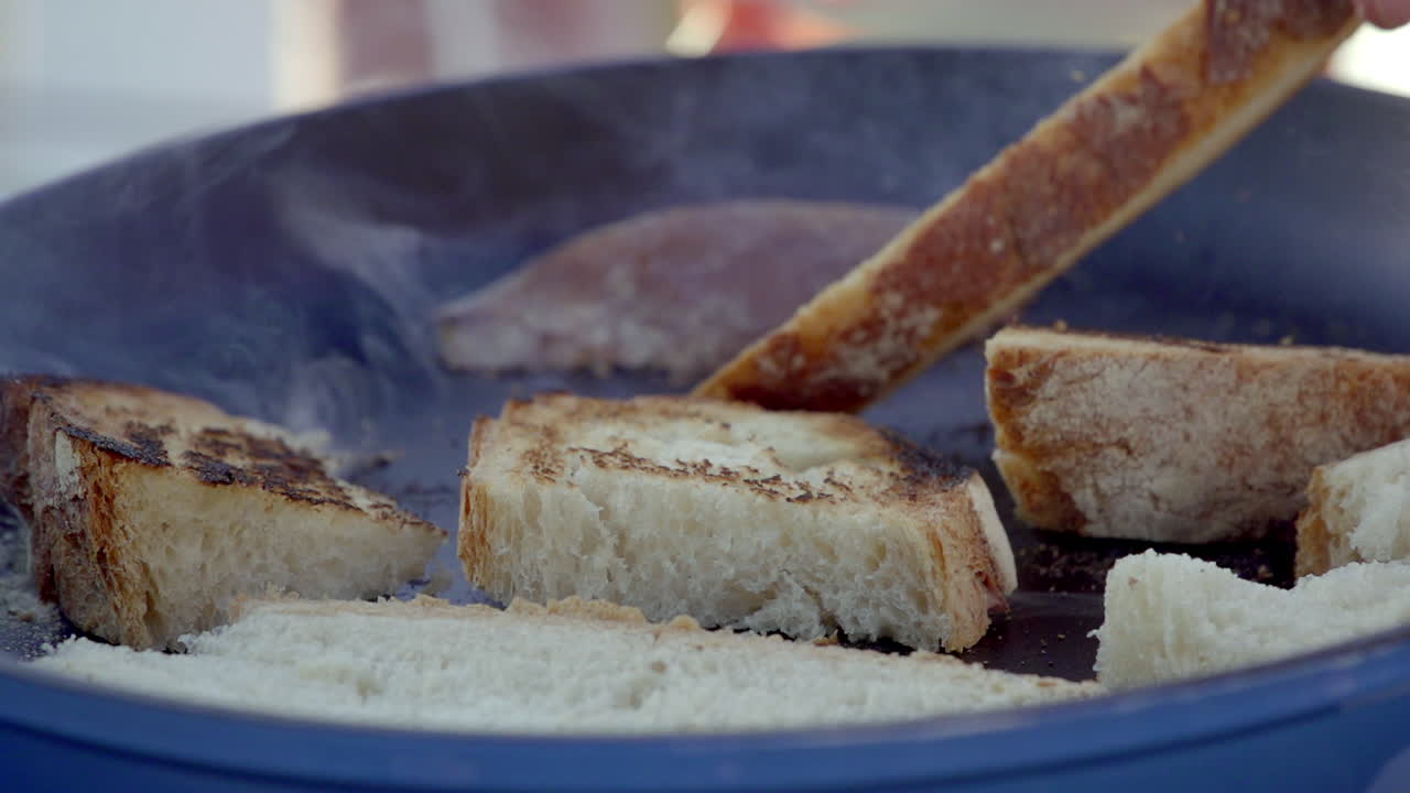 Hands toasting bread in a pan
