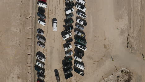 top-down aerial view of a van looking for parking in the desert