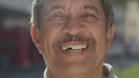 portrait of happy middle aged mixed race man smiling in city