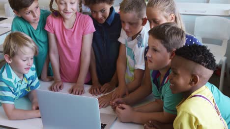 grupo de niños que usan computadora portátil en la clase