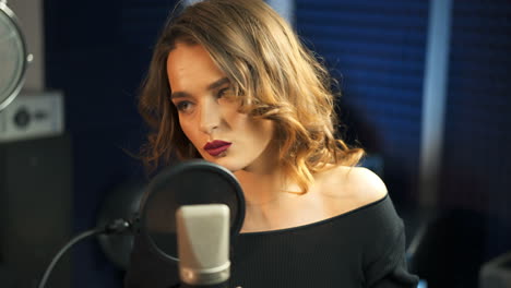 young girl singing into a microphone in a studio. close-up of a singer.