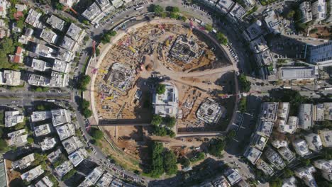 toma cenital de un sitio de construcción en una gran plaza de la ciudad mientras los autos pasan