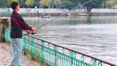 man fishing at a pond in hanoi, vietnam