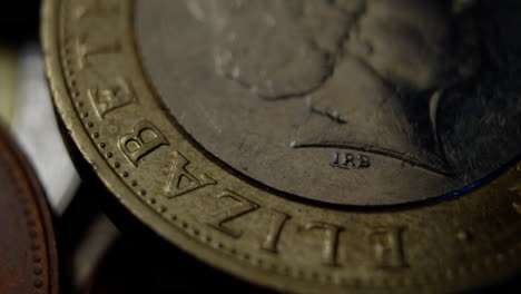 detailed macro view of a british pound coin showing engraved letters and textures under moody lighting