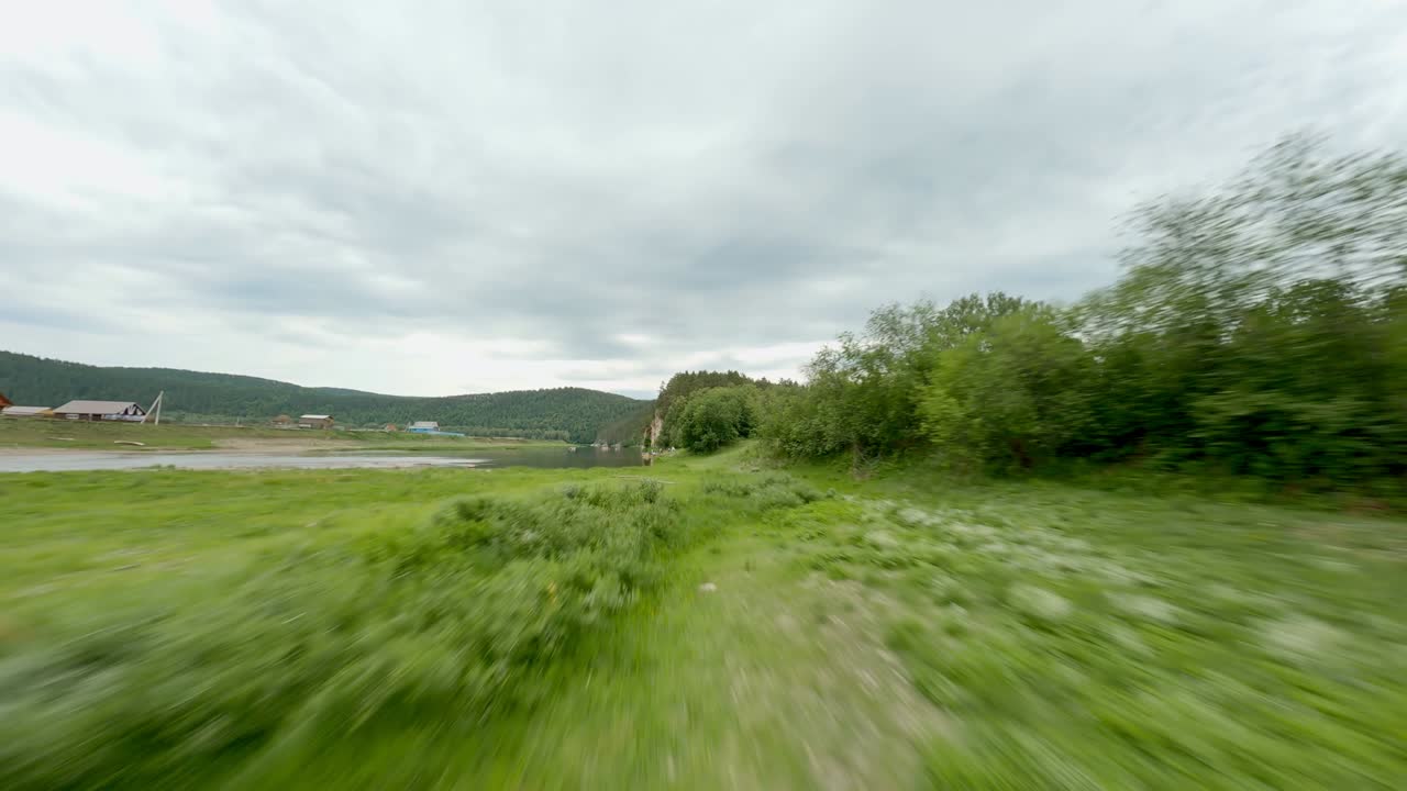 The village is located in a picturesque area in the valley. Rocky mountains, forests and rivers. Life in the fresh air. A group of people rest on the river bank.