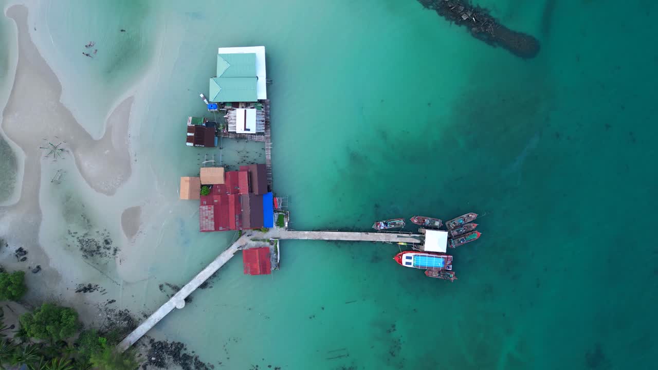 cambodia Koh Rong island, capturing the essence of tropical paradise with its lush palm trees, vibrant turquoise waters, and traditional stilt houses. Gorgeous aerial view drone top down Above view