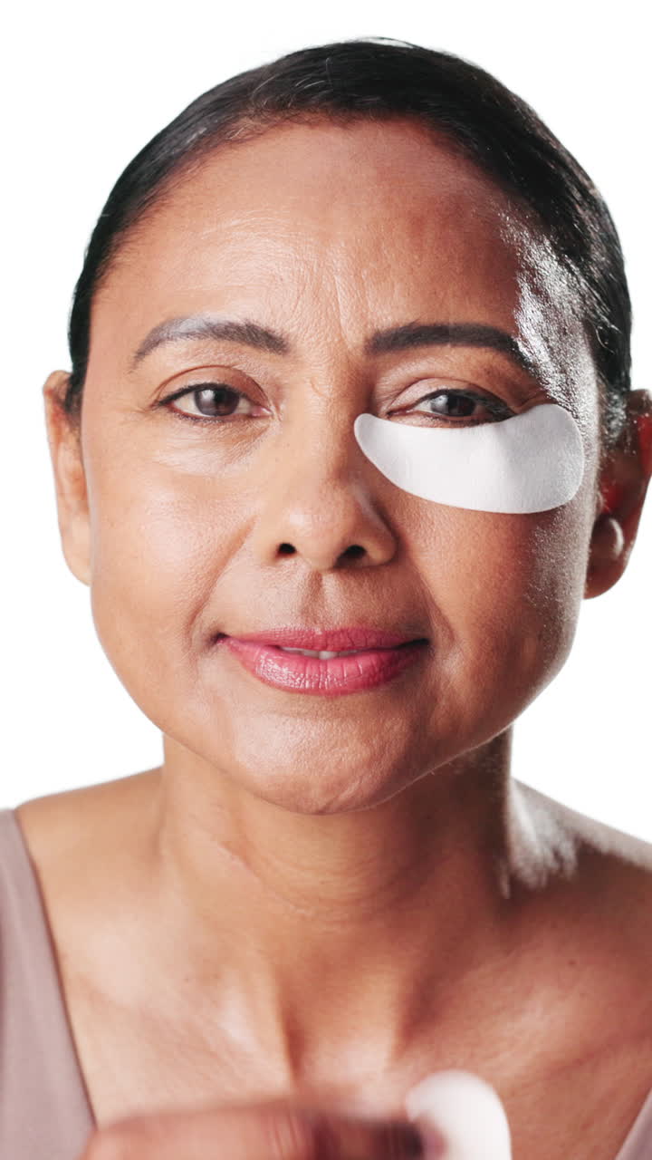 Mature Woman Applying Under-Eye Patches for Skincare