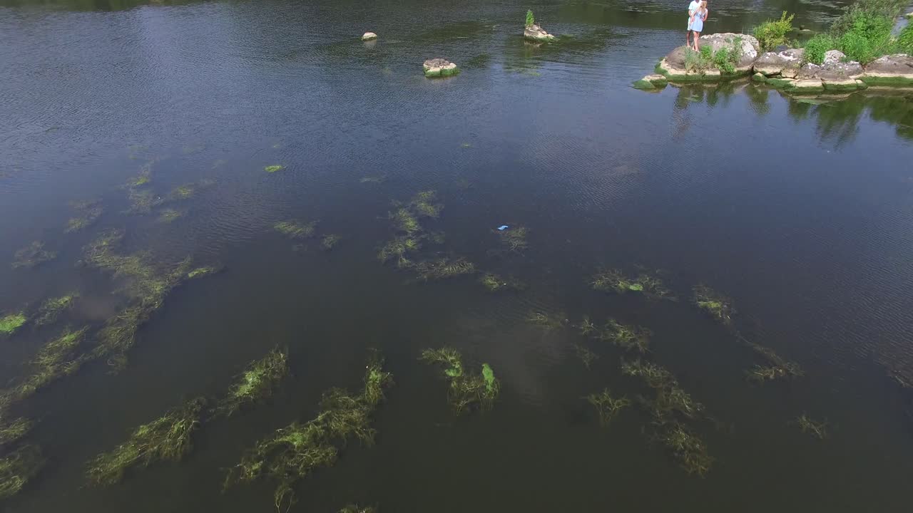 Romantic Couple Enjoying Outdoors. Aerial shot of a handsome guy and beautiful girl resting in river