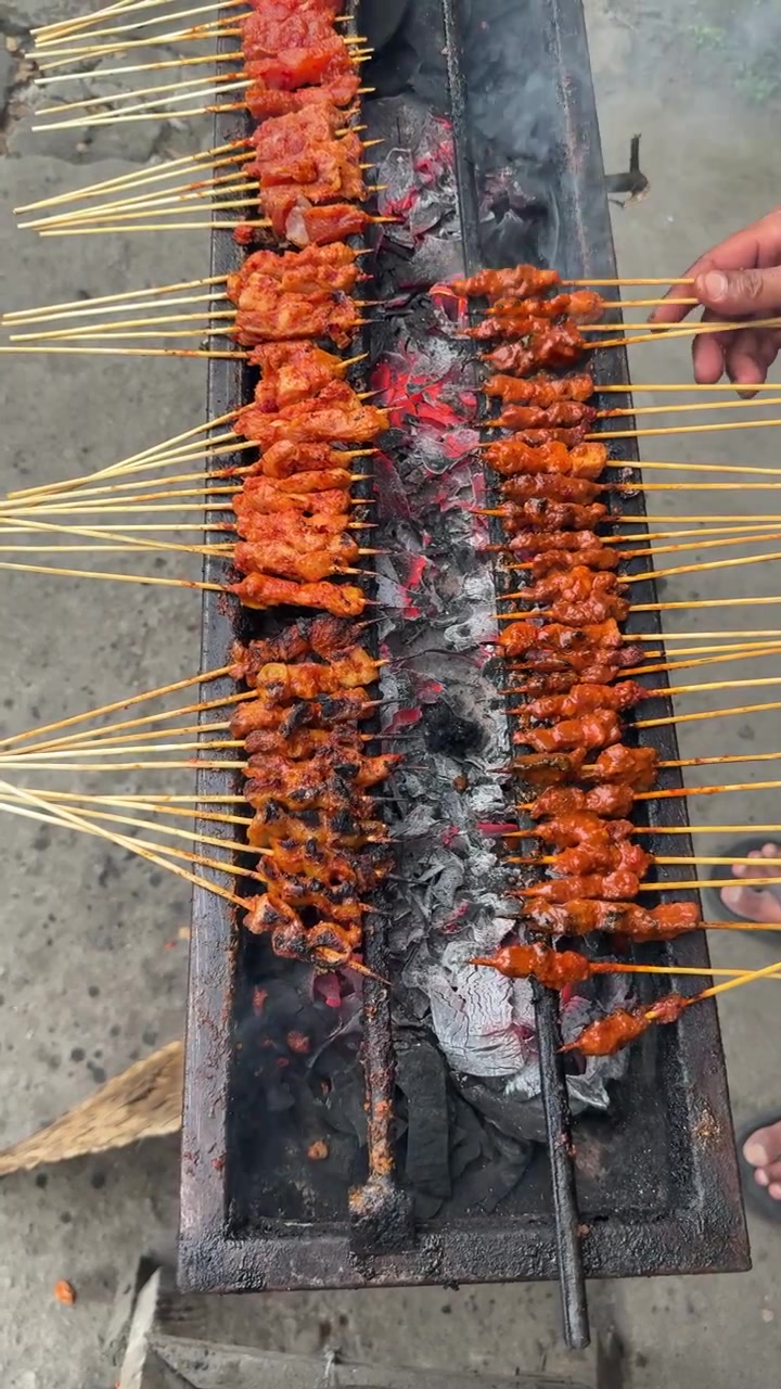 Grigliatura di spiedini satay tradizionali su carboni ardenti
