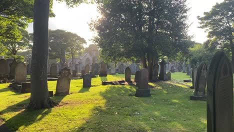 Static-tripod-shot-of-headstones-and-graves-in-a-cemetery-at-sunset