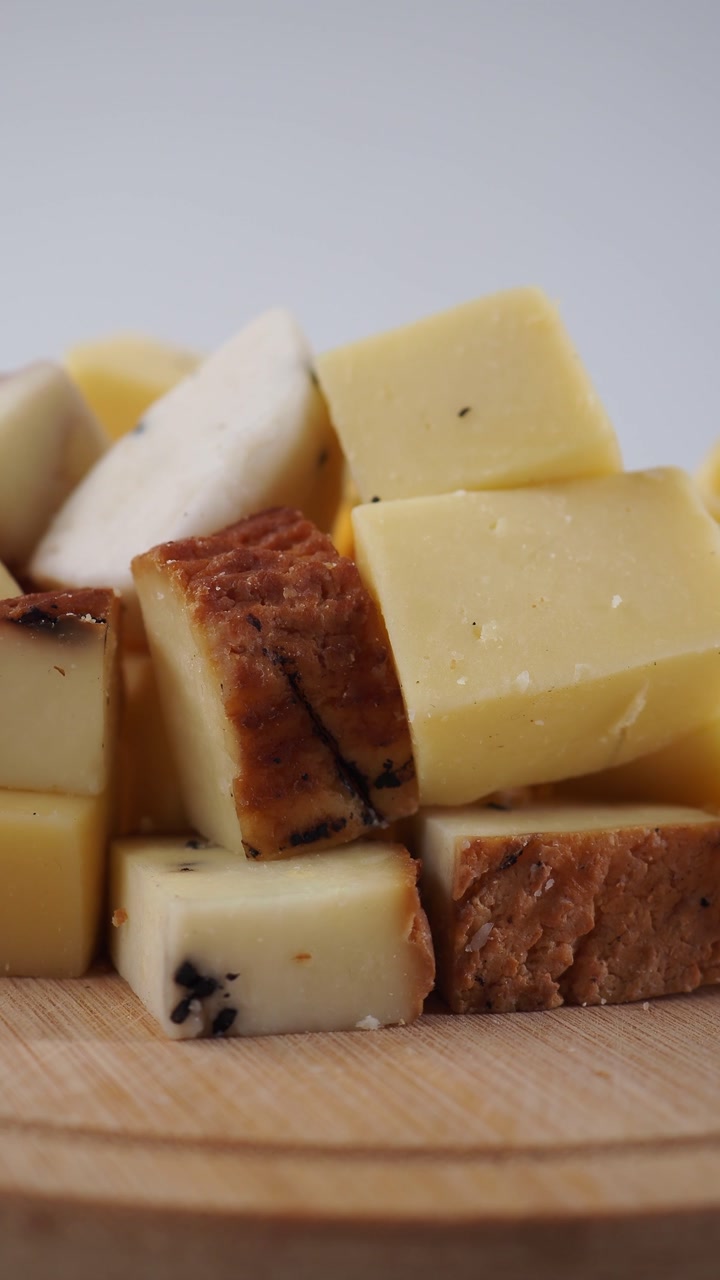 Close-up of Assorted Cheese Cubes on a Wooden Board