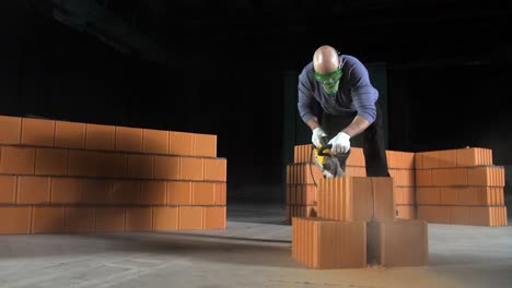 trabajador de la construcción cortando ladrillos con herramientas eléctricas