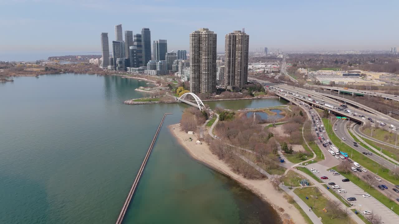 Humber Bay Arch Bridge and Parklawn skyline with highway traffic in Toronto, aerial