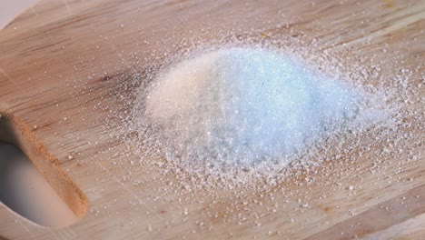 Mound-of-White-Sugar-Rotating-on-a-Wooden-Board