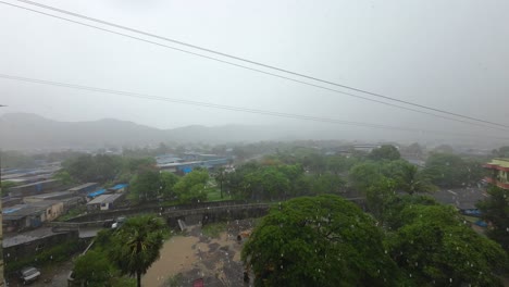 Starker-Regen-Mit-Maske-über-Den-Bergen,-Bewegung,-Gebäude,-Balkon,-Regenzeit