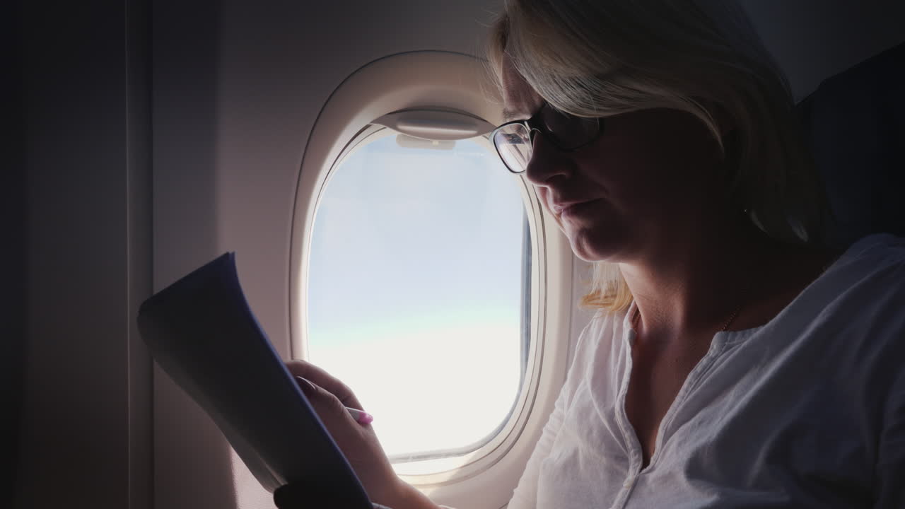 비즈니스 여자는 비행기 비즈니스 및 여행에 대한 문서를 읽고 있습니다