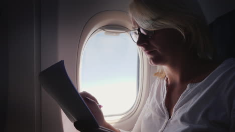 business woman is reading documents on the plane business and travel