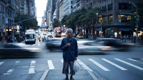 an elderly individual stands at a bustling intersection in new york city, surrounded by rushing cars and pedestrians as twilight descends. the atmosphere blends urban vibrancy and solitude.