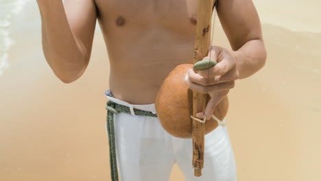 shirtless man playing instrument