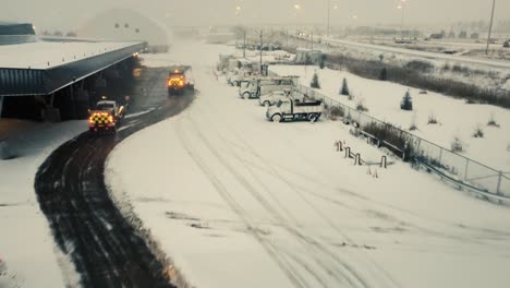 Schwerer-Schneepflug-LKW-Reinigt-Privates-Industriegebiet-Bei-Schneefall,-Luftaufnahme