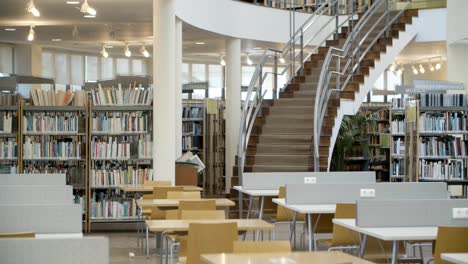 interior of library with books on shelves and stairs