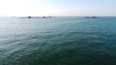 Fast-aerial-forward-view-of-fish-farming-platforms-in-the-sea