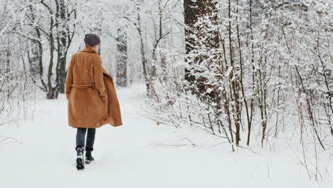 Active-Woman-In-Classic-Coat-Walks-Through-Snowy-Park