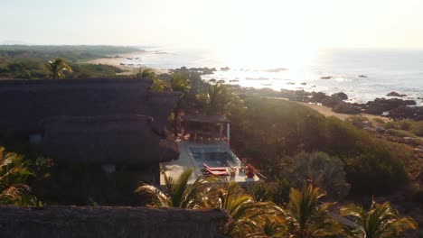 drone lento pan alrededor de villa de alquiler de lujo en oaxaca mexico, frente al mar 4k amanecer aéreo