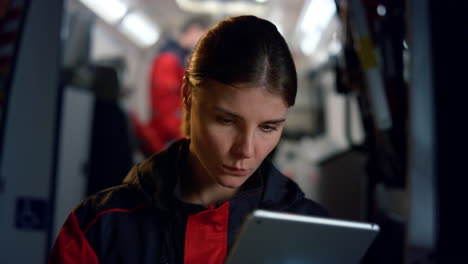 paramédico trabajando en una computadora tablet. mujer pensativa navegando en la red de redes sociales