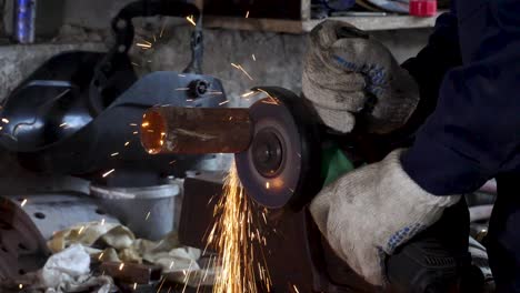 metal pipe cutting with grinder in workshop