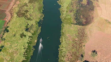 Top-down-drone-follow-shot-of-a-typical-long-boat-on-Inle-Lake-in-Myanmar