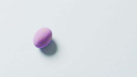 un huevo de pascua púrpura en fondo verde con espacio de copia