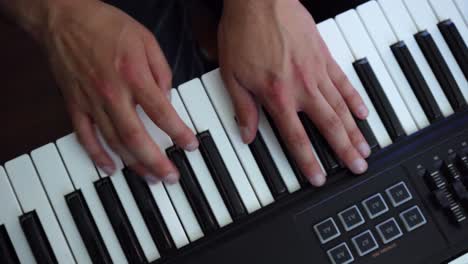 Top-view-shot-of-the-hands-of-a-pianist-playing-his-instrument