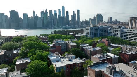 vuelo aéreo hacia adelante sobre el idílico barrio de brooklyn heights y el reflejo del sol en el east river en el fondo - vista panorámica del horizonte de nueva york con edificios rascacielos