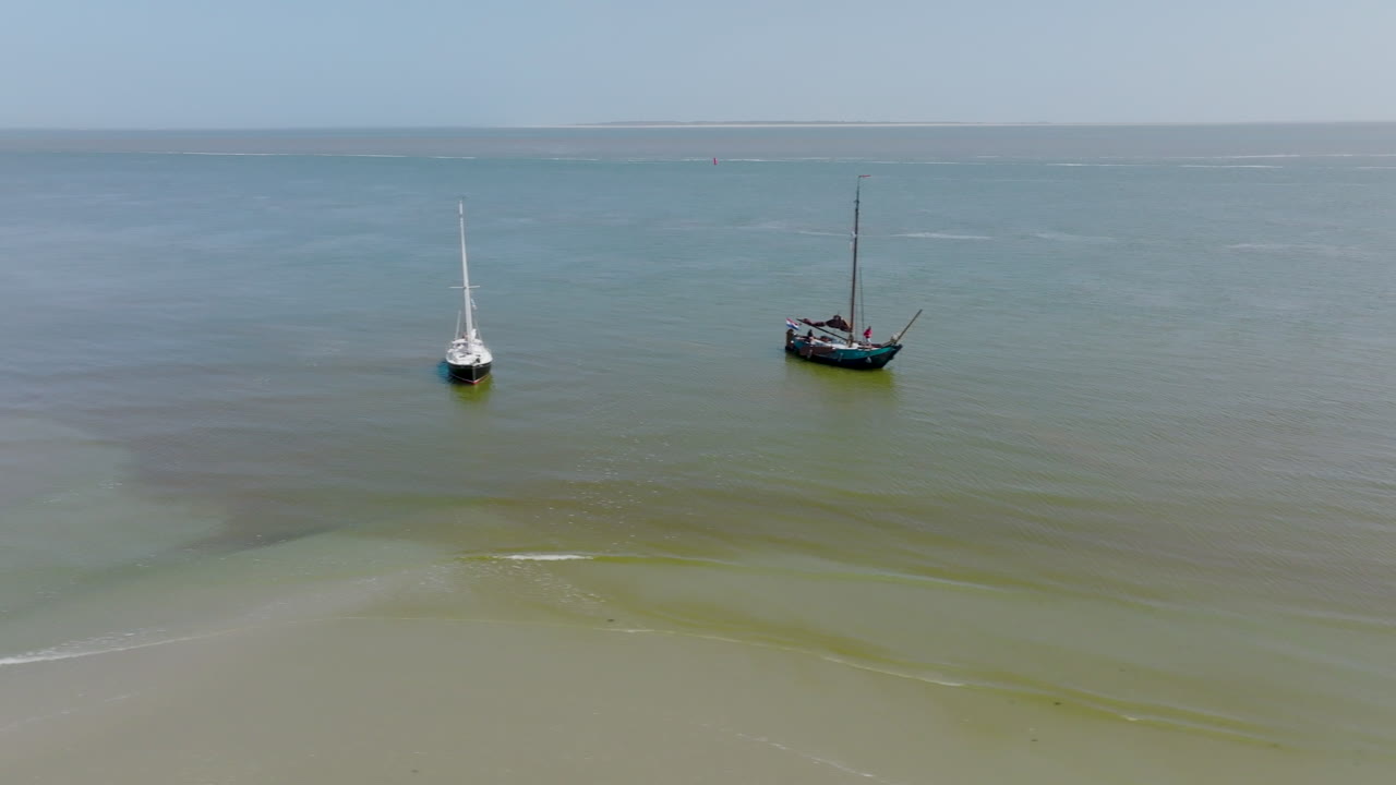 Aerial view of a group of boats in the Wadden Sea at low tide on a sunny day. The Netherlands