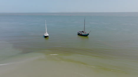 aerial view of a group of boats in the wadden sea at low tide on a sunny day. the netherlands
