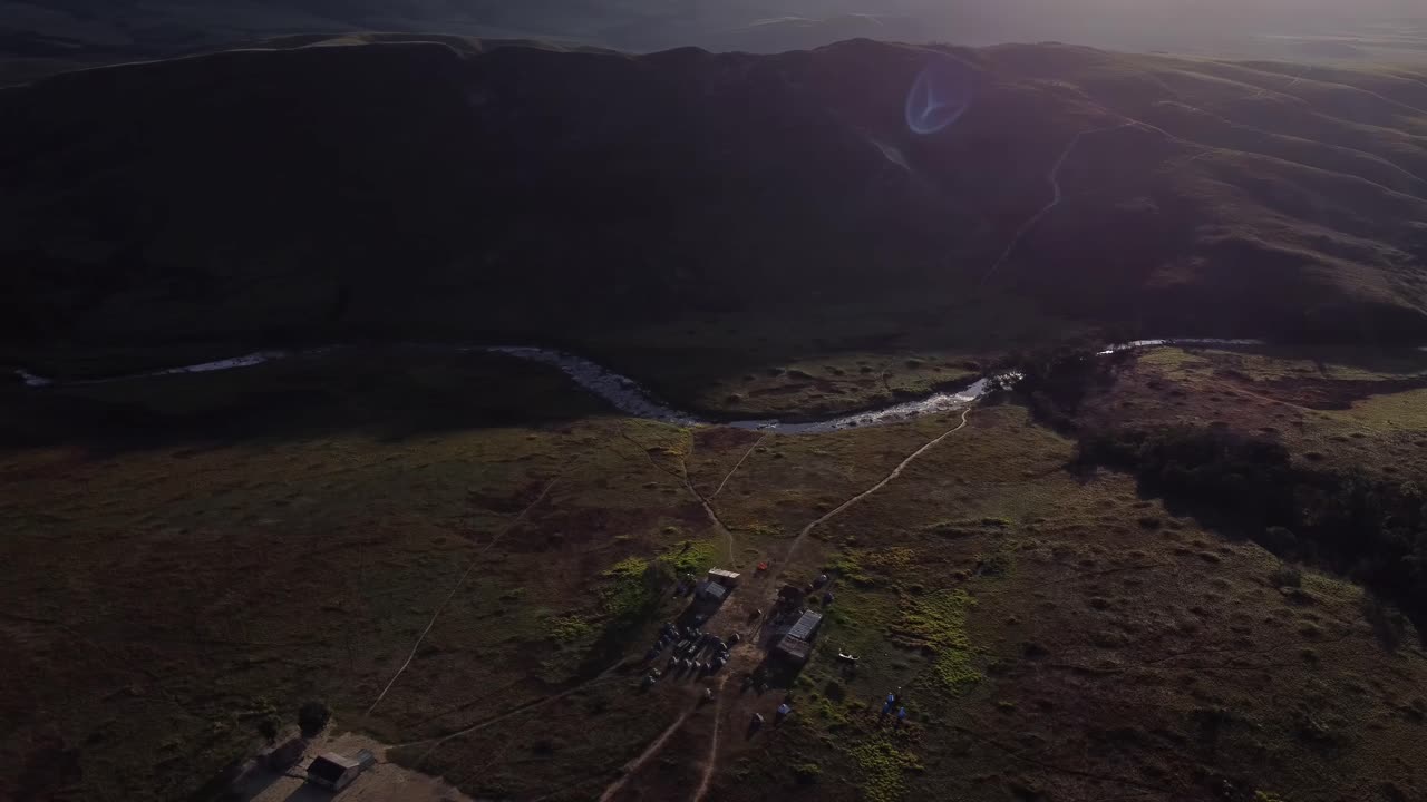 Aerial tilt down view revealing campsite in middle of Roraima Tepuy valley at sunrise