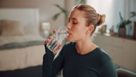 woman drinking water in her bedroom