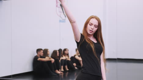 female dance student at performing arts school performs street dance for class in studio