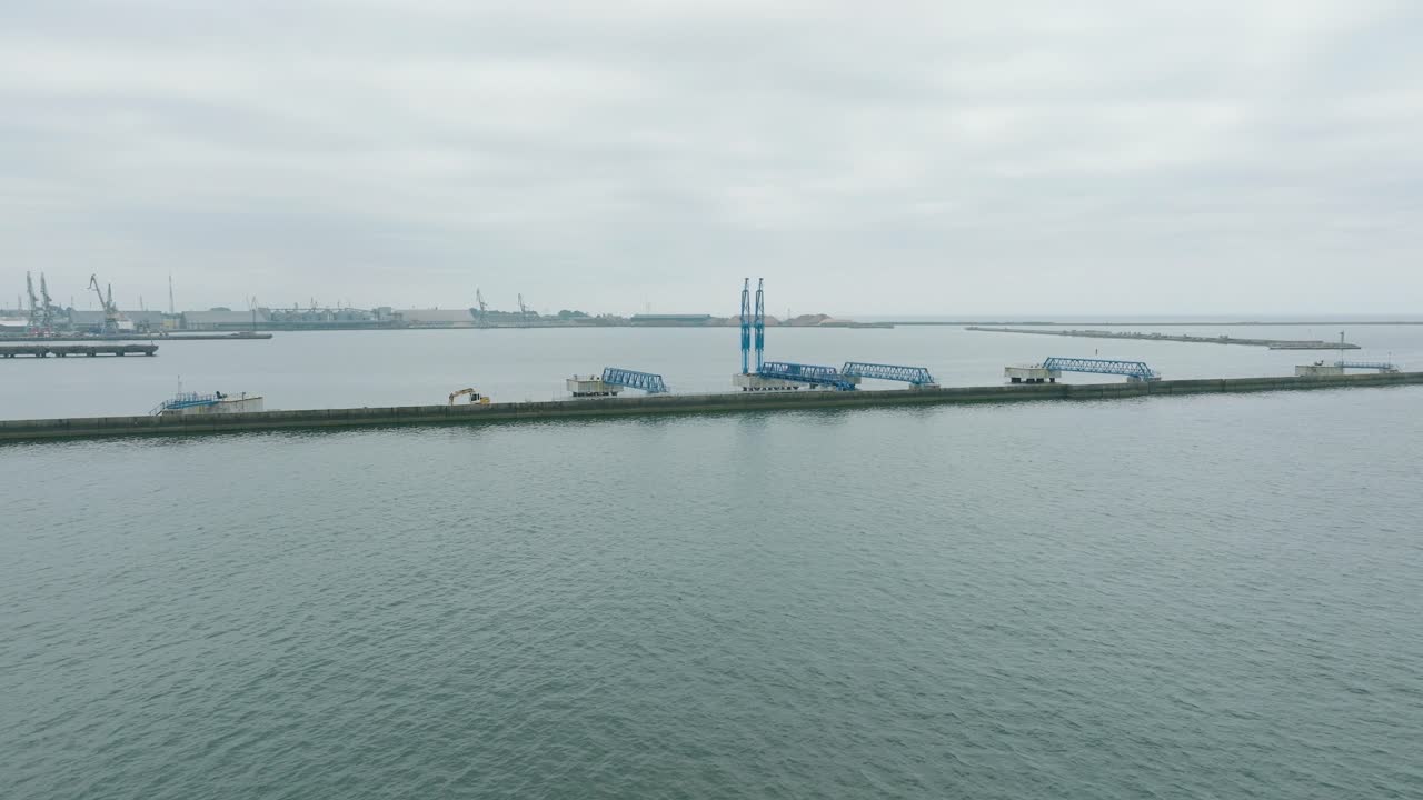 리페자 항구의 항구 크레인과 비어있는 로딩 도크의 공중 뷰, 배경에는 리페자 도시, 구름이 가득한 여름 날, 넓은 드론  ⁇ 이 앞으로 움직입니다.