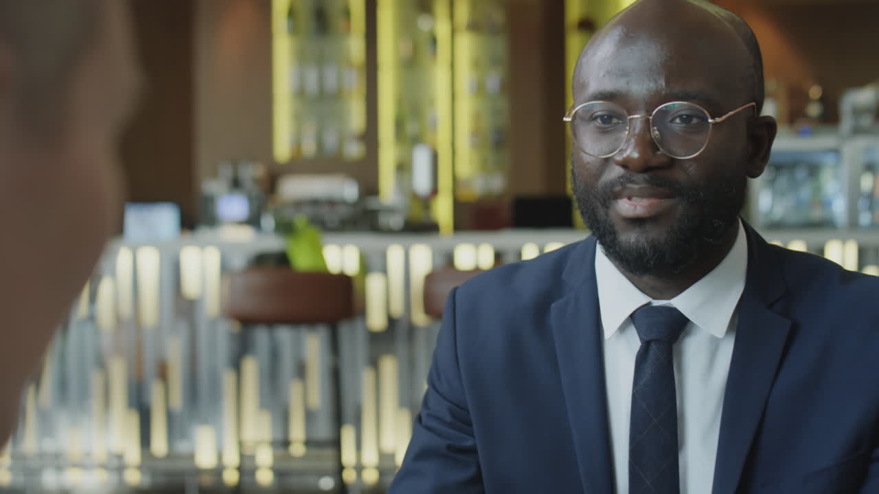 Black Businessman Speaking with Colleague in Restaurant