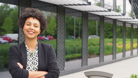 Portrait-Of-Smiling-Businesswoman-Standing-Outside-Modern-Office-Building