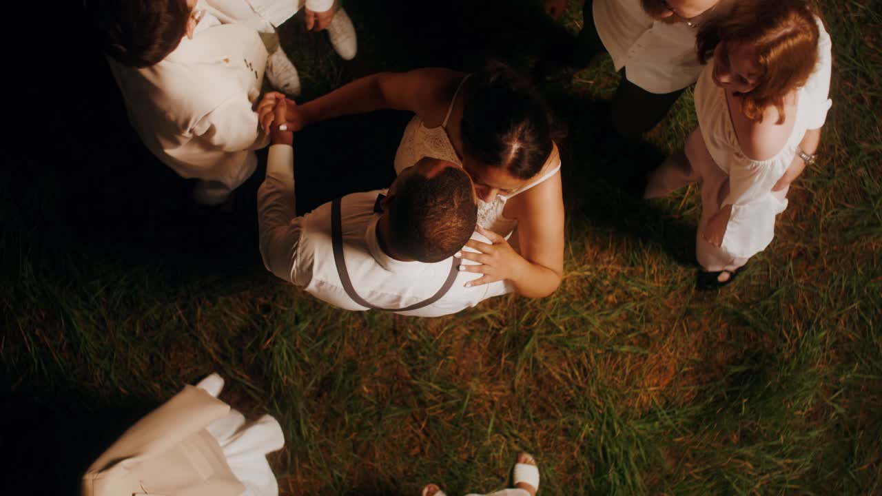 한 부부가 손님들과 함께 원으로 춤을 추고 있다