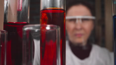 una mujer experta toma una muestra de sangre de un tubo de ensayo