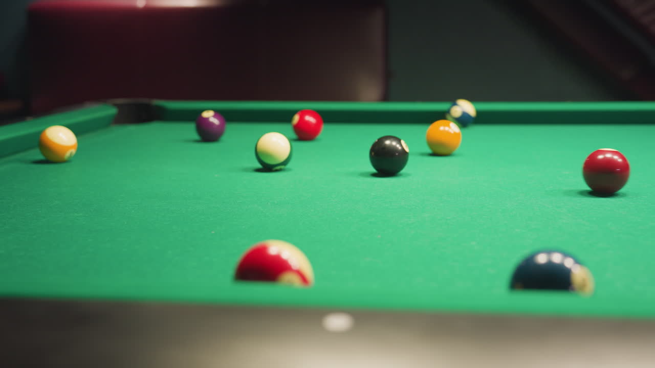 bolas de billar esparcidas por la mesa de billar verde después de un tiro de descanso, capturadas en movimiento. colores vibrantes y posicionamiento dinámico crean una sensación de acción en la sala de billar, destacando la competencia, la precisión