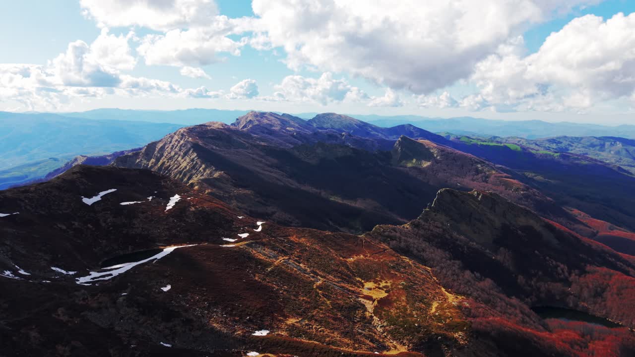 Majestic aerial view over rocky Dolomites ridges under bright sky and scattered clouds