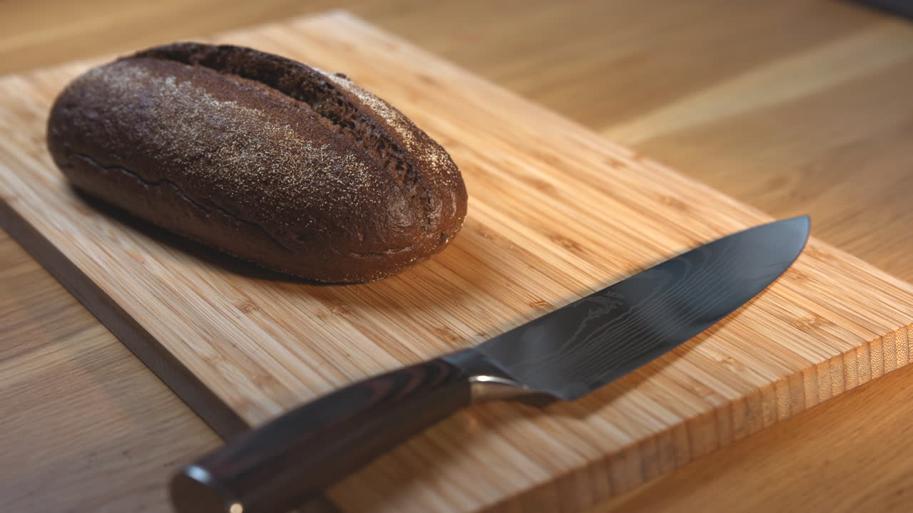 Cutting bread on a wooden cutting board with a knife