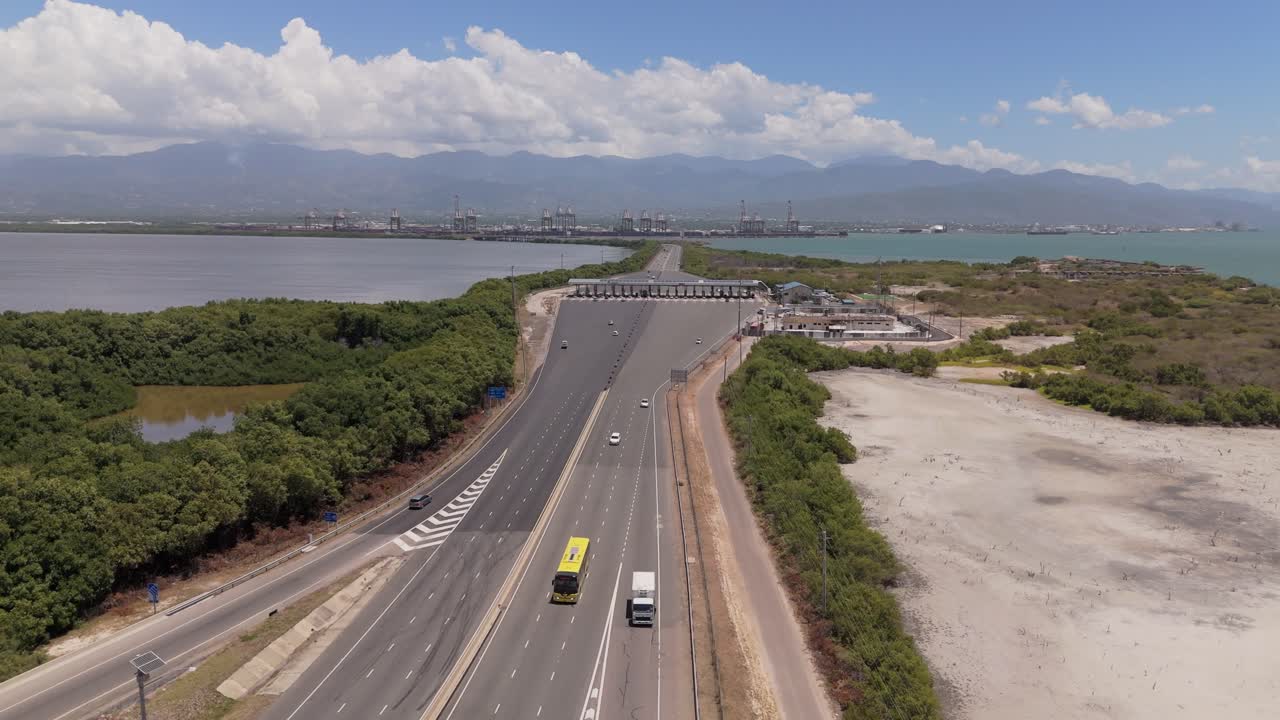 Aerial view of the Portmore toll booth and highway in Jamaica, highlighting road design, traffic flow, and surrounding urban layout.