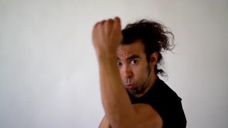 Hispanic-Boxer-With-Goatee-and-Ponytail-Punching-Toward-Camera-in-Slow-Motion,-close-up